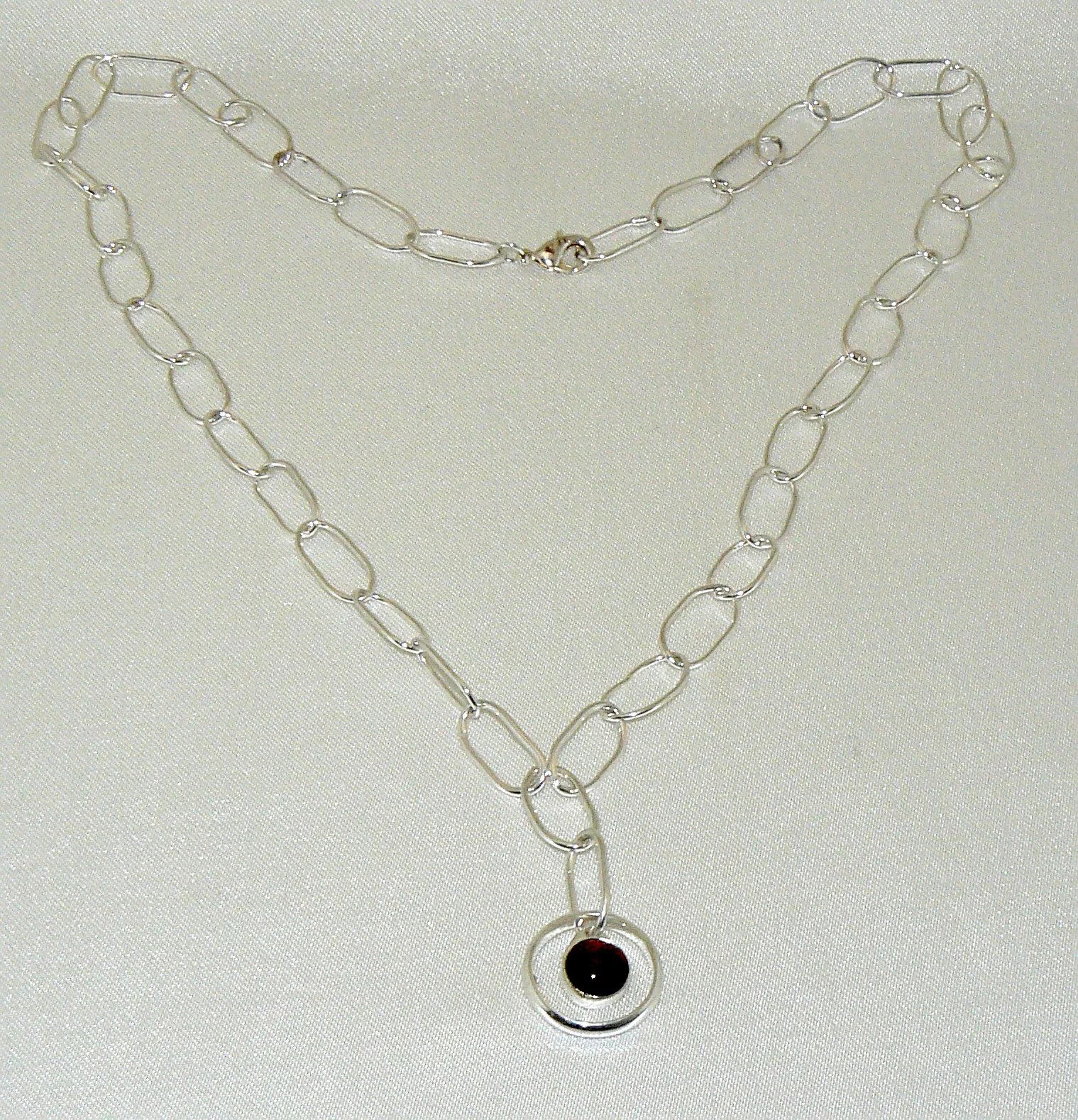 Red tiger's Eye cabochon pendant suspended in a ring, sterling silver on a handmade sterling chain, 20mm on 300mm chain with parrot catch.