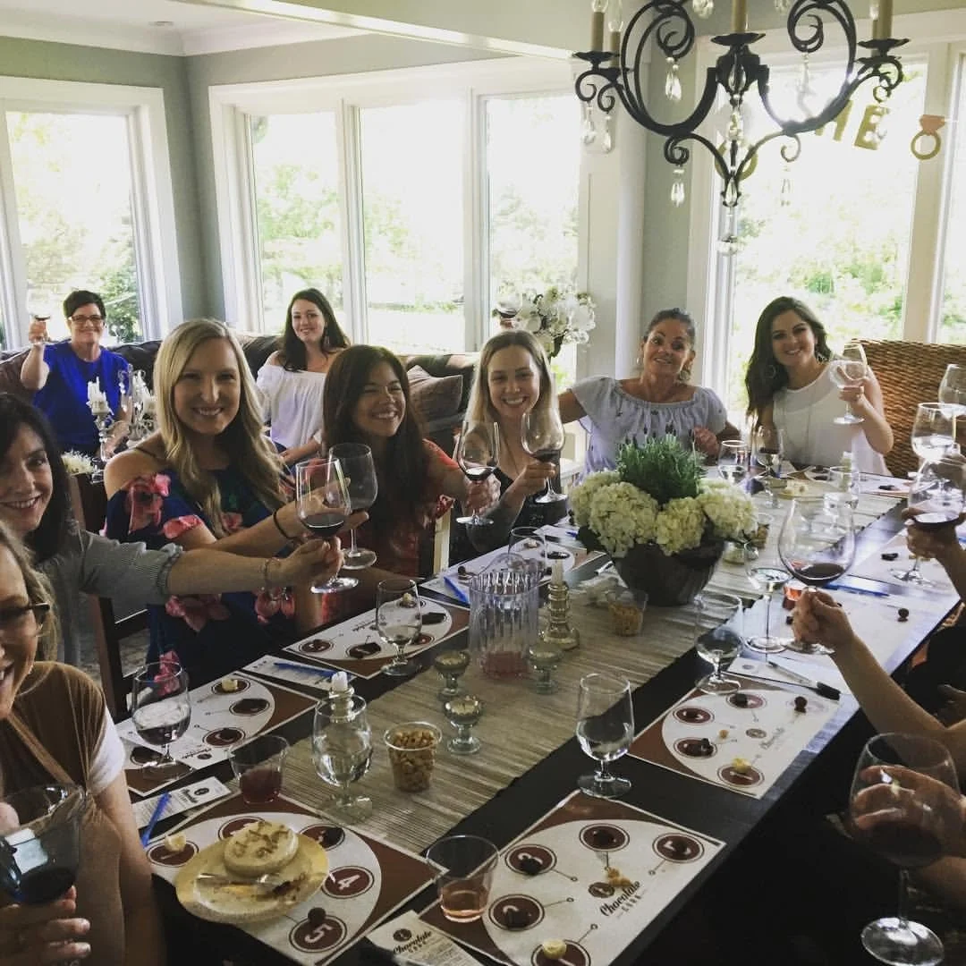 Guests sharing chocolate and wine pairings around a dining table.