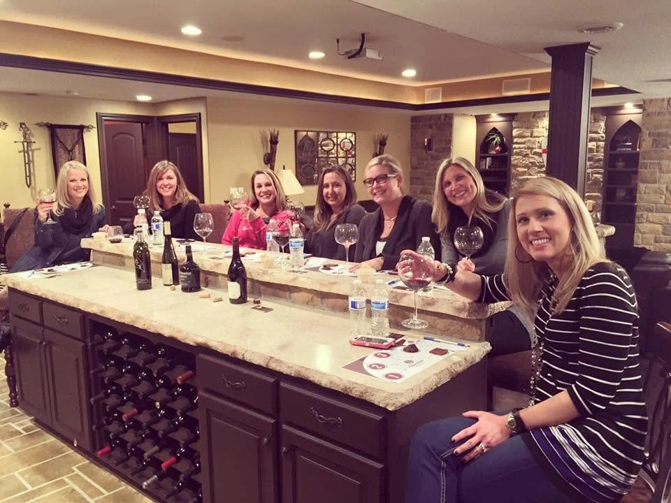 Friends enjoying a Chocolate Cork tasting around a kitchen island.