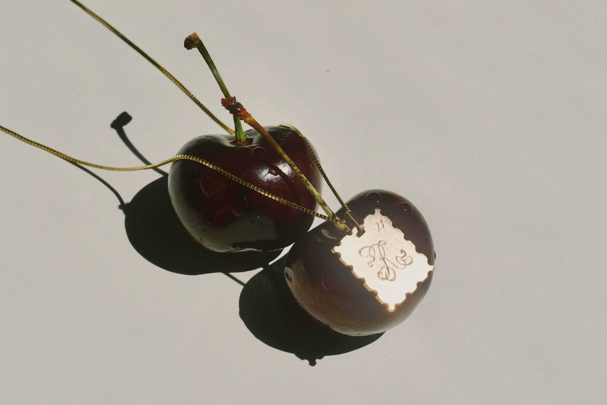 A hand-engraved charm on top of cherries