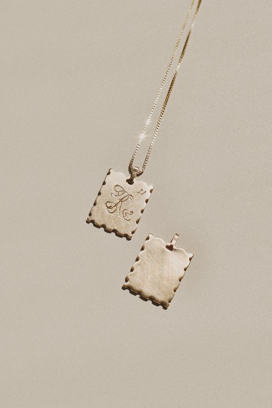 Vintage gold necklace with an engraved rectangular pendant and matching scalloped rectangular charm