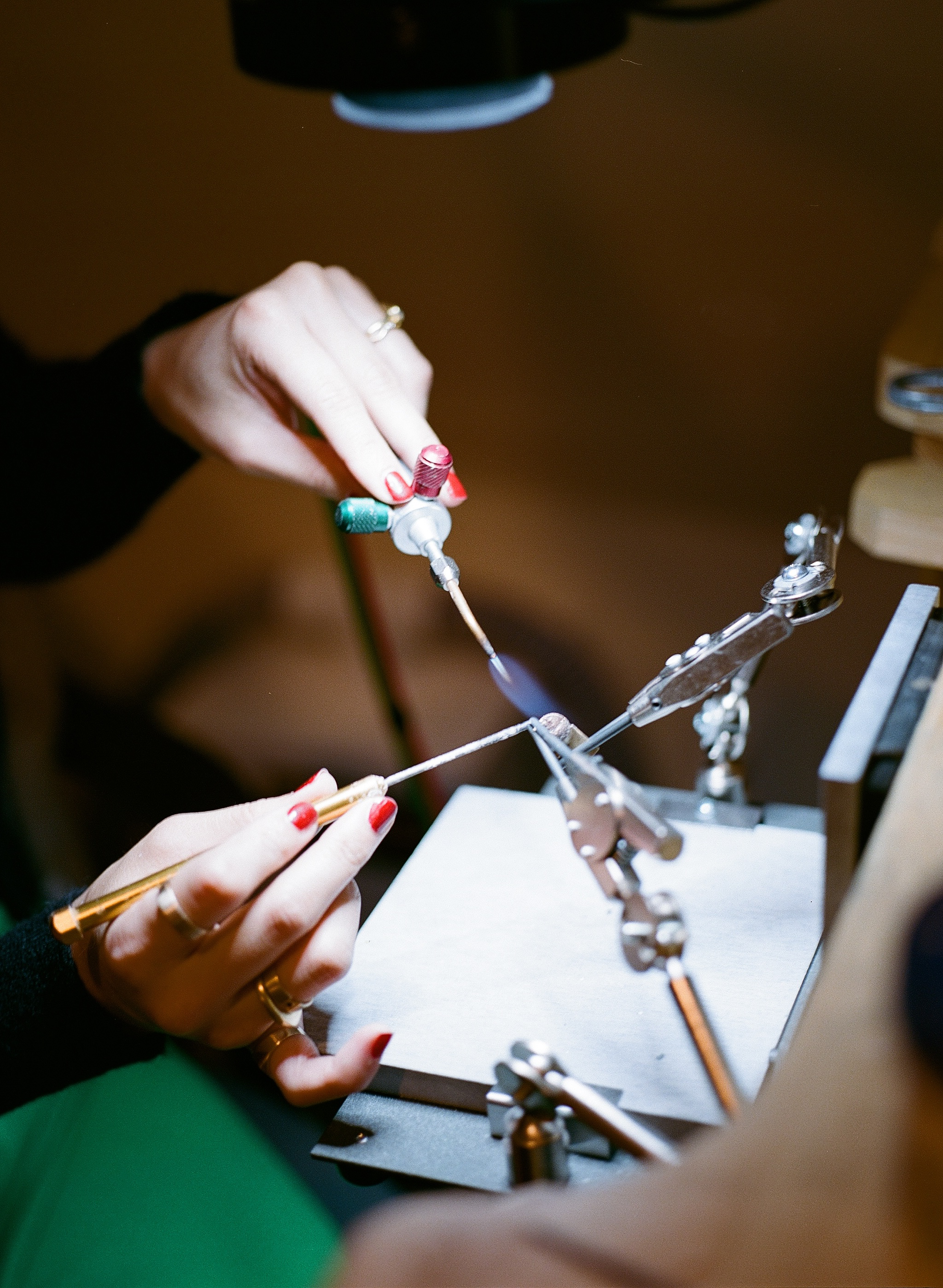 Close-up of a musician adjusting a violin bridge and strings with a tuning tool.