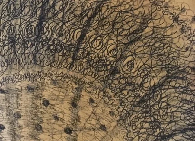 Abstract black ink doodle with dense looping lines, spirals, and textured patterns on tan paper