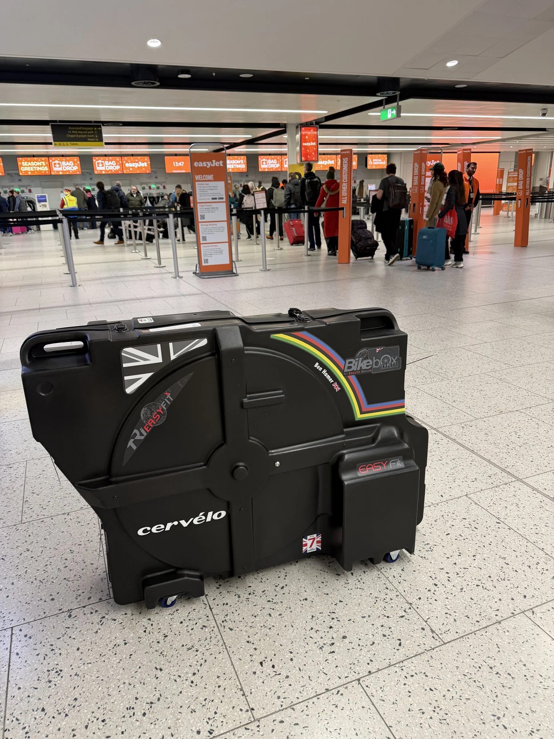 Bike Box Alan hard bike case at the easyJet bag drop in an airport departures hall