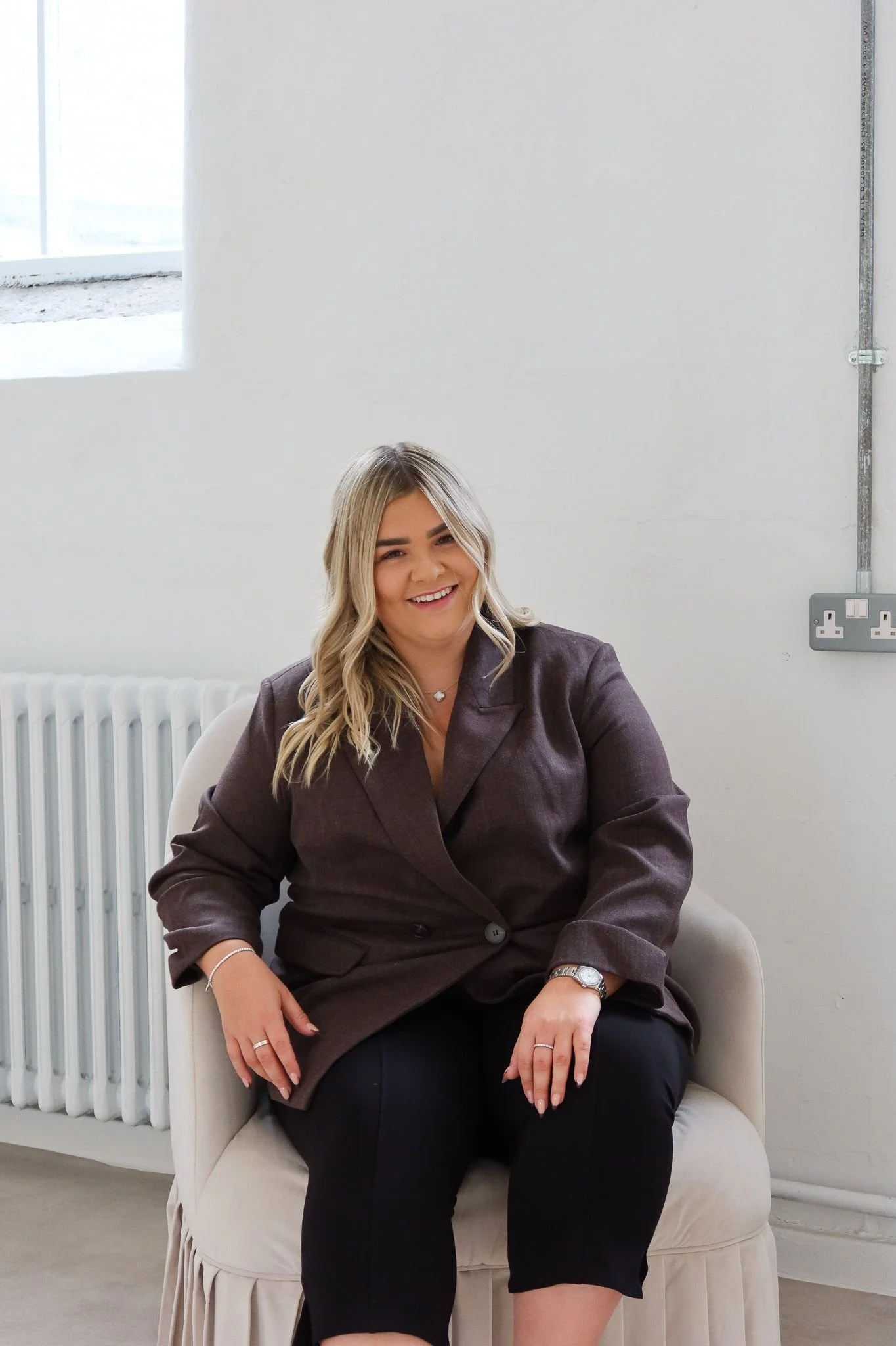 Smiling founder seated in a bright studio during a lifestyle content shoot