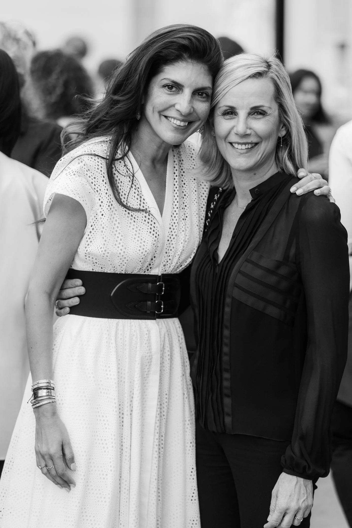 Portrait en noir et blanc de deux femmes souriantes posant ensemble lors d’un événement.