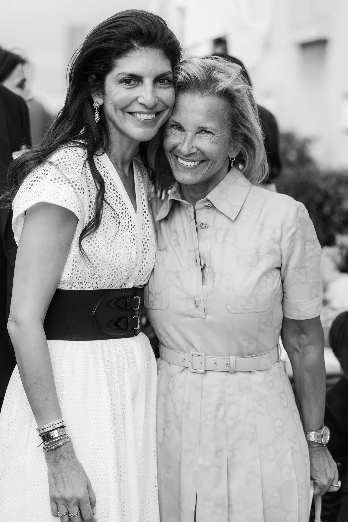 Deux femmes souriantes posant ensemble lors d’un événement, en noir et blanc.