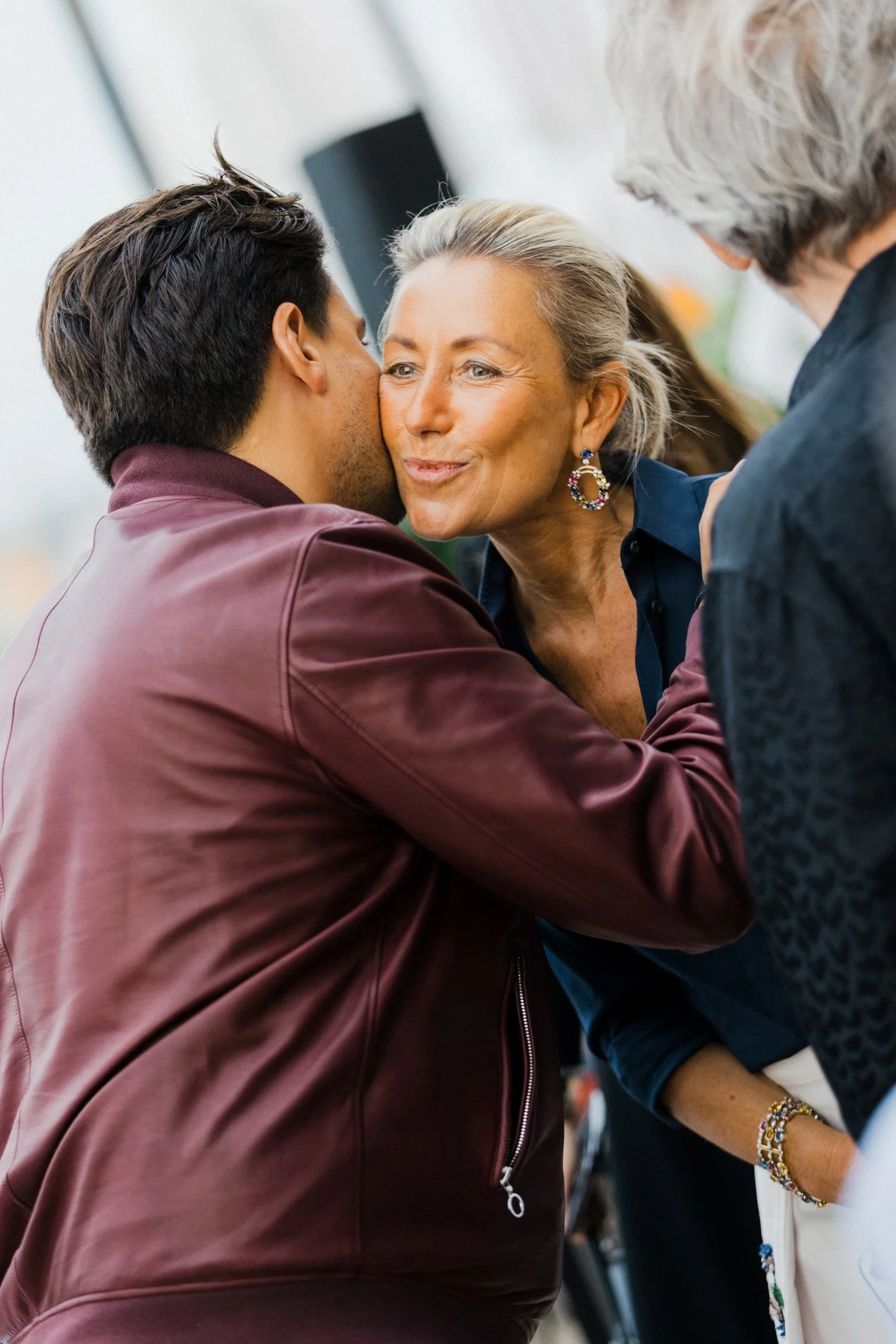 Un homme embrasse une femme âgée sur la joue lors d’une rencontre conviviale.