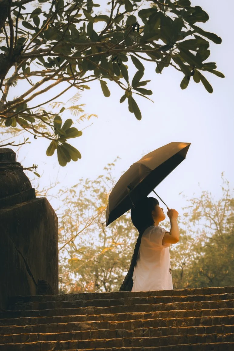 Woman looks skyward to the looming Wat Umong in Chiang Rai, Thailand.