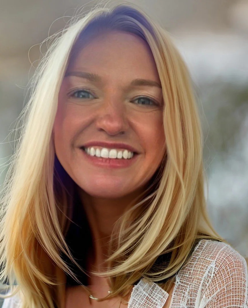 Close-up portrait of a smiling blonde woman wearing a light textured top.