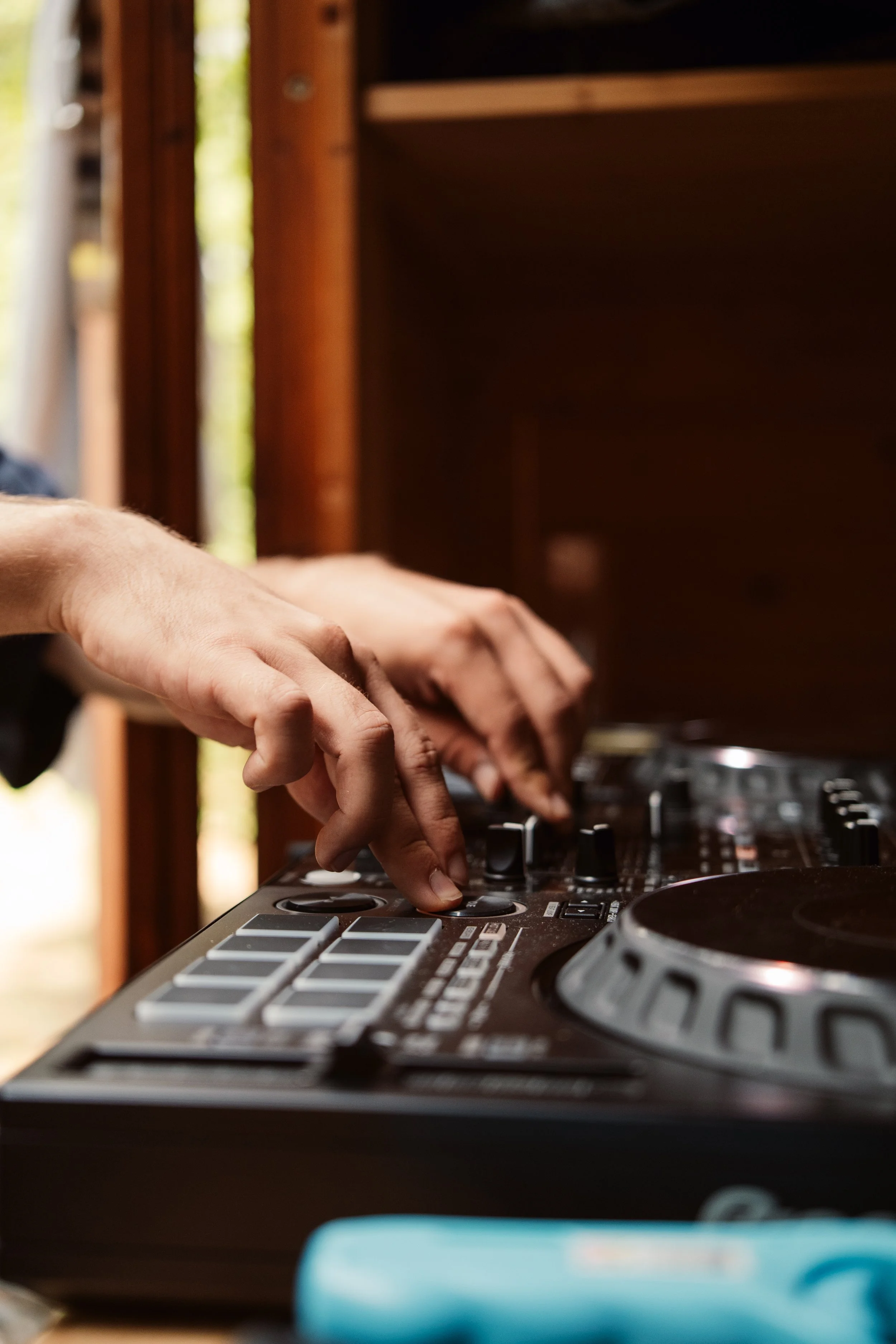 Close-up of a hand adjusting knobs on a professional DJ mixer.