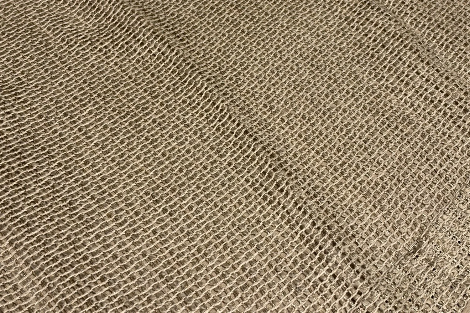 Open-weave linen look drapery fabric laid flat on the workroom table