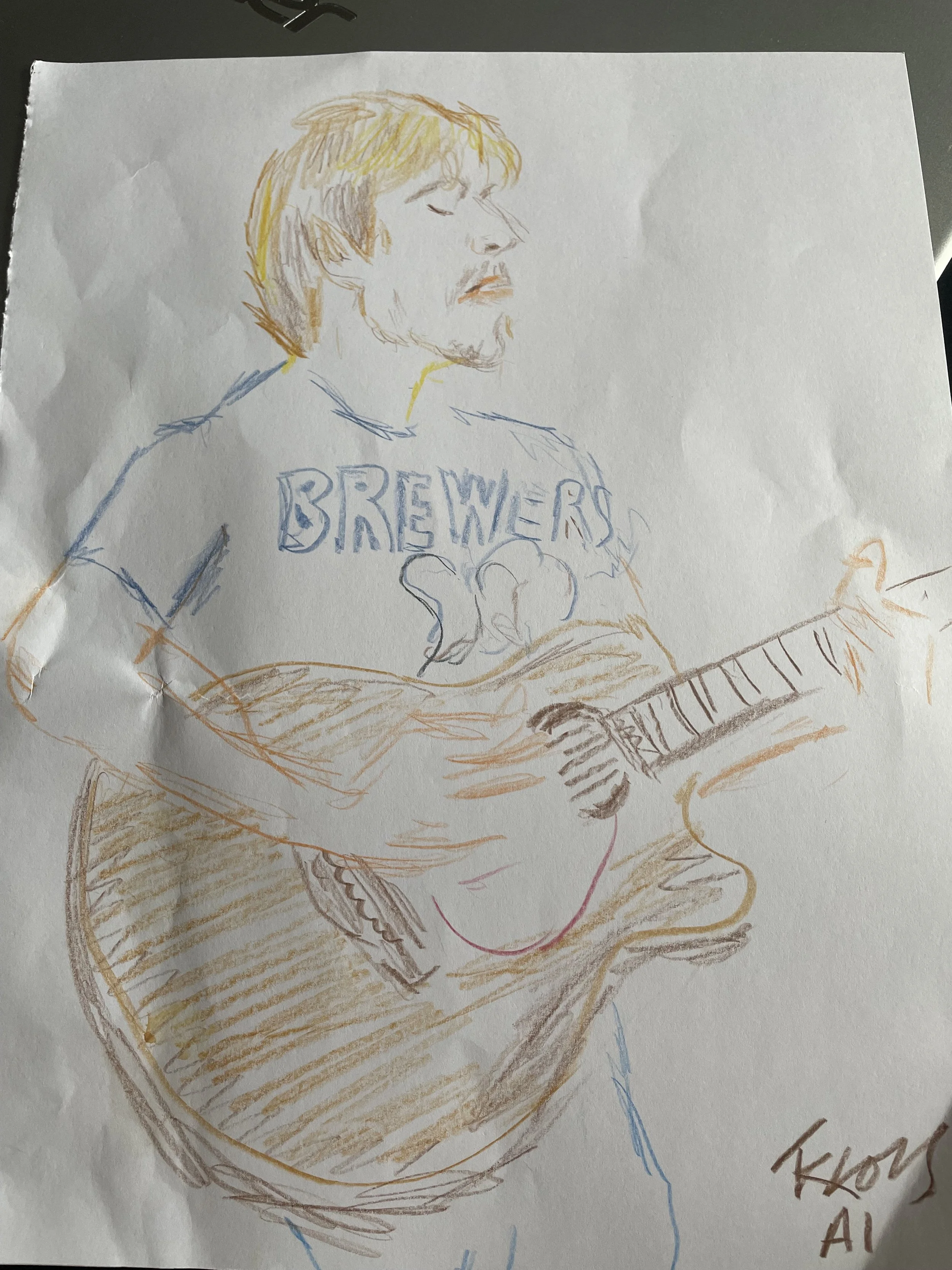 Color-pencil drawing of a blond-haired person playing a piano, with “BREWER” written on their shirt.