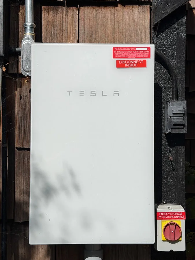 Tesla electrical energy storage system disconnect box mounted on an exterior wooden wall