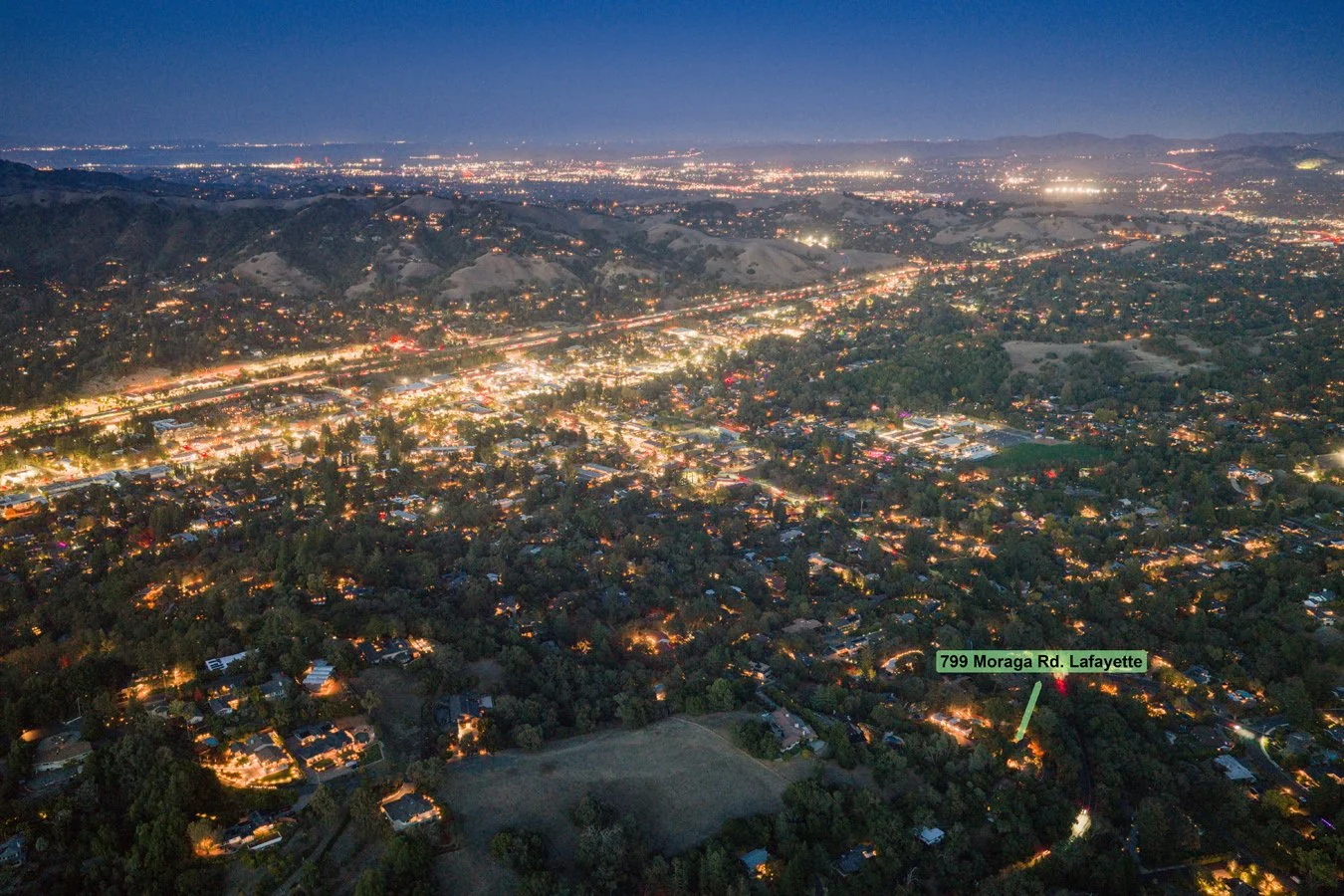 Aerial twilight view of Lafayette, California, showing city lights, rolling hills, neighborhoods, and the labeled property at 799 Moraga Road.