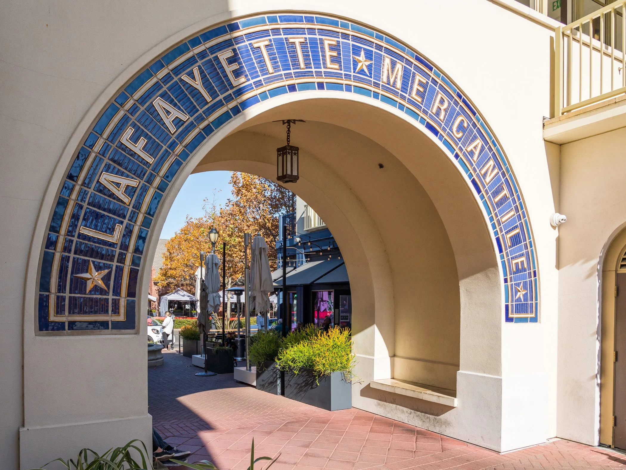 Blue tiled archway reading “Fayetteville” at an outdoor shopping and dining plaza.