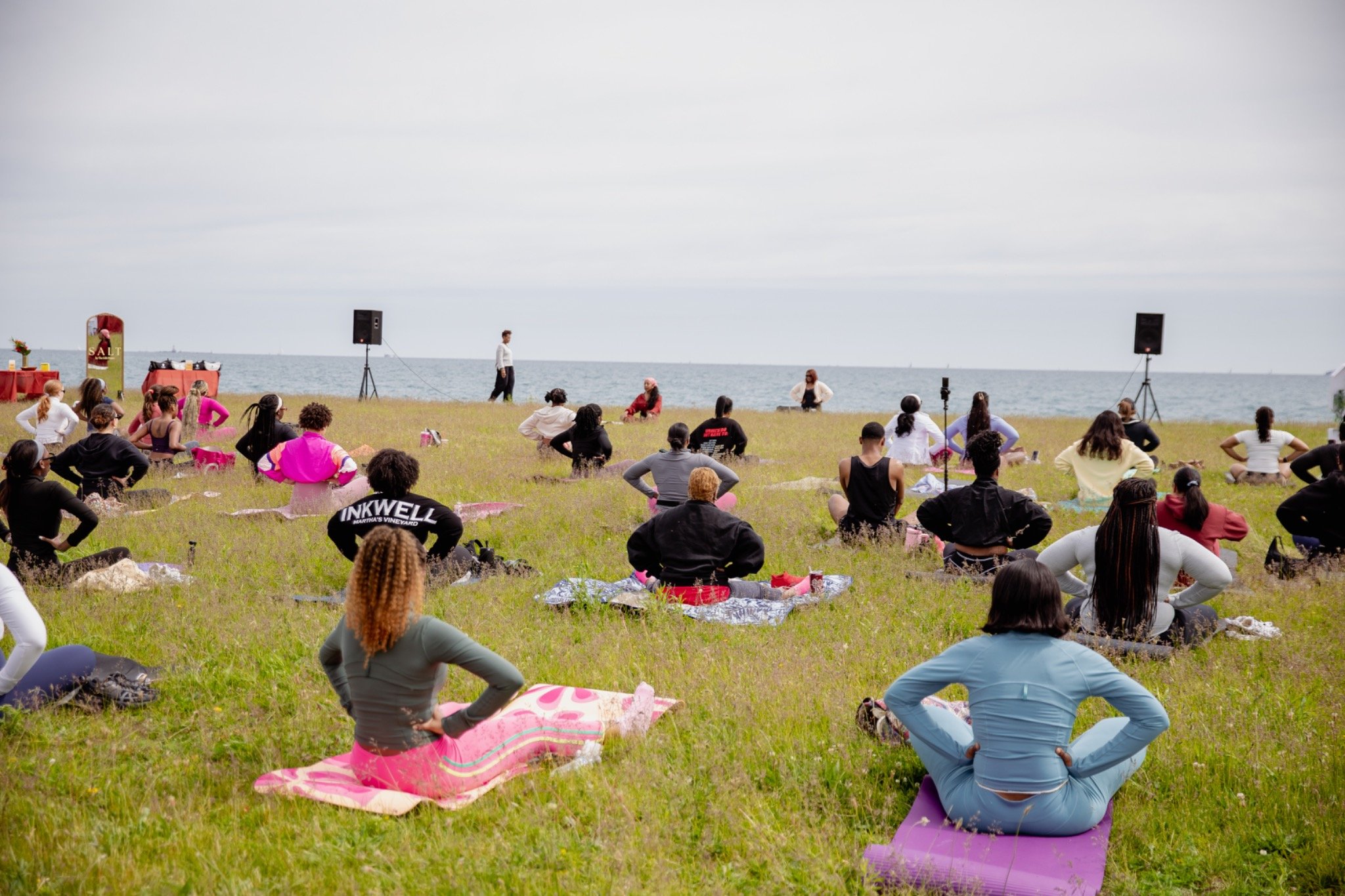 Community members taking part in an outdoor Pilates class overlooking Lake Michigan.