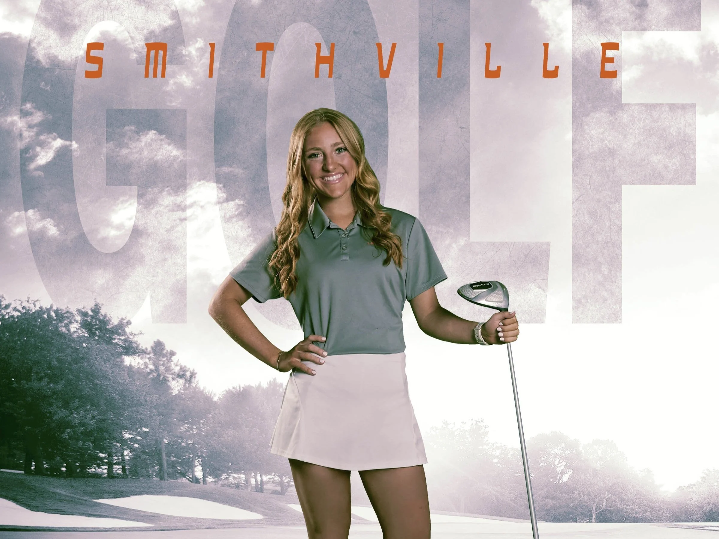 A young woman with long wavy blonde hair, smiling, standing outdoors on a golf course, holding a golf club with her right hand and wearing a grey polo shirt and white skirt. The background features trees and cloudy sky with the word 'SMITHVILLE' written across in large, semi-transparent text.