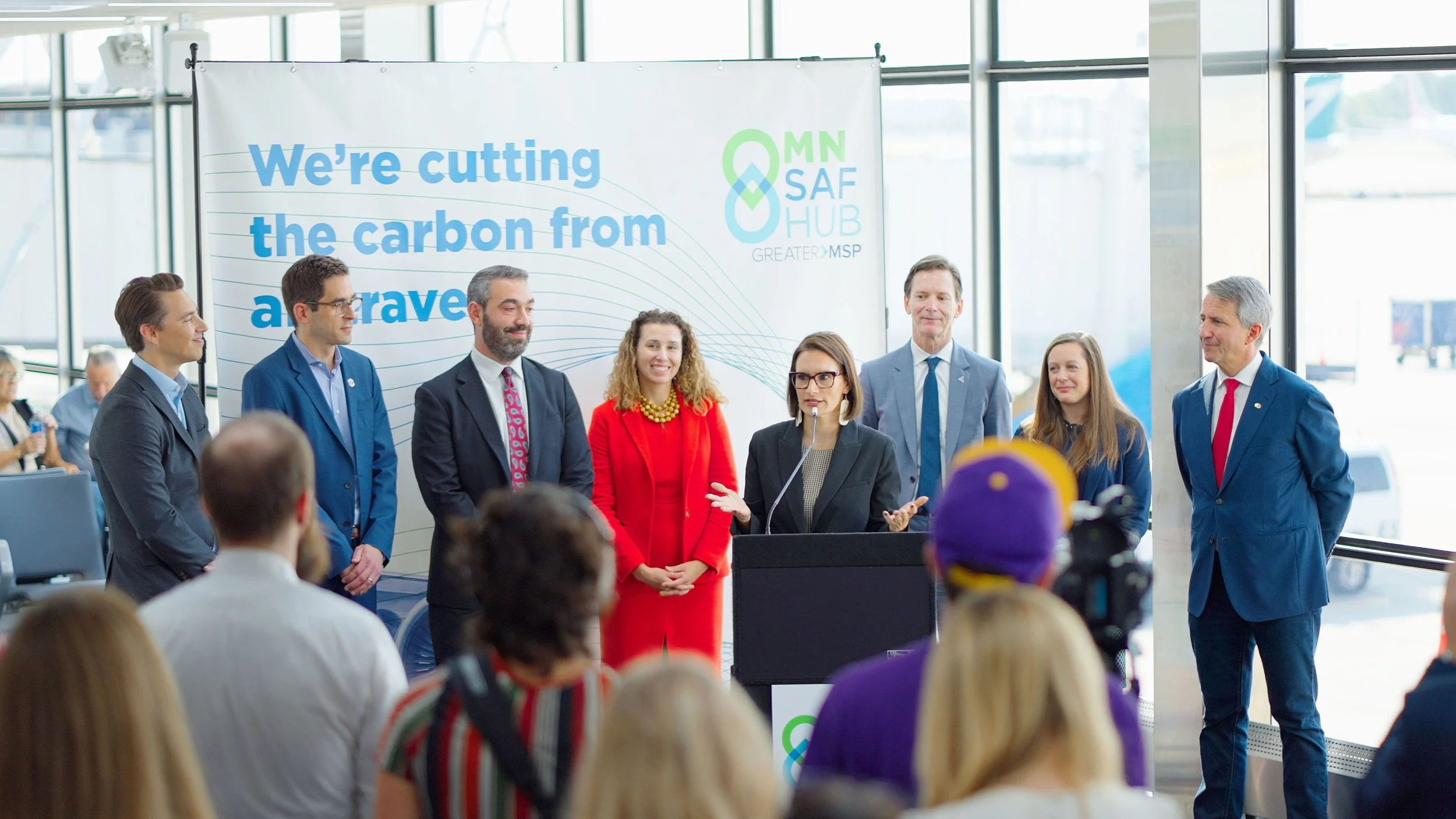 Climate leaders speak at a Greater MSP announcement about cutting carbon emissions, with a panel and audience.