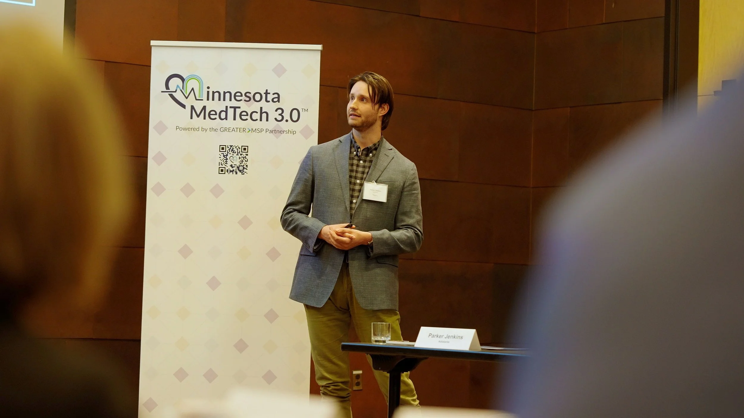Speaker Parker Jenkins at a Minnesota MedTech 3.0 event beside a branded banner.