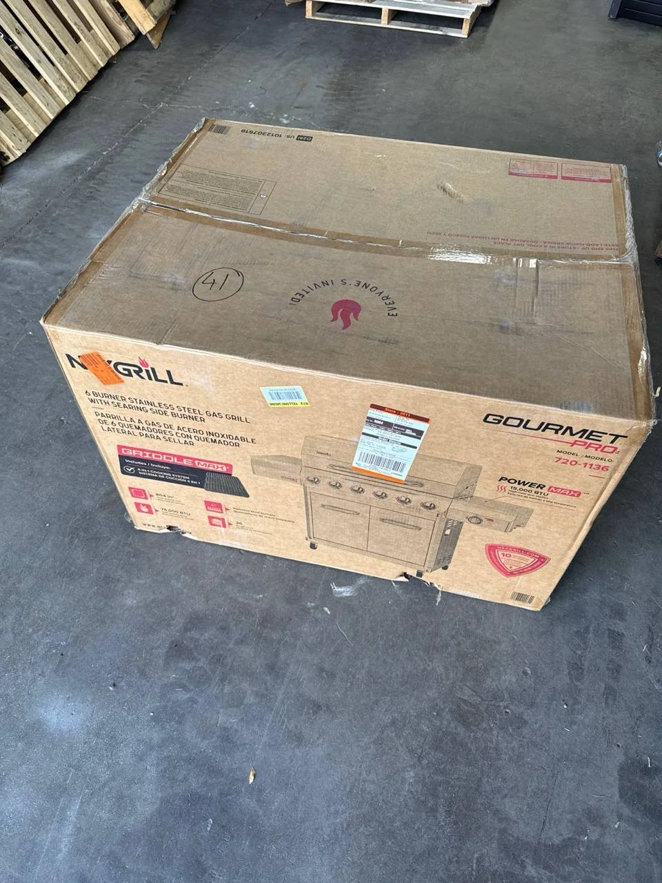 Nexgrill Gourmet Pro 6-burner stainless steel propane gas grill in its original cardboard box, front view