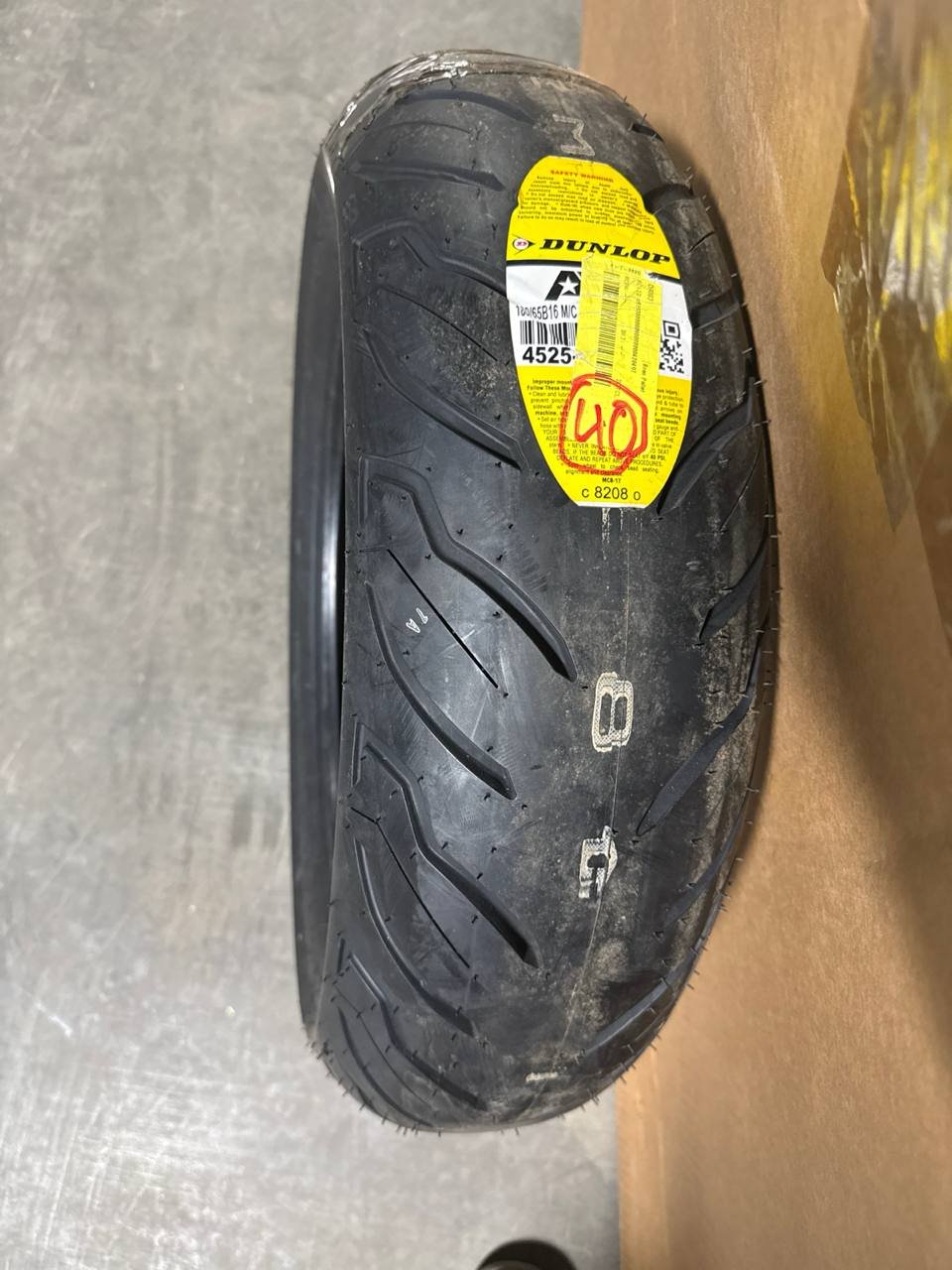 Close-up of the Dunlop American Elite AE2 rear tire tread and sidewall label in the warehouse