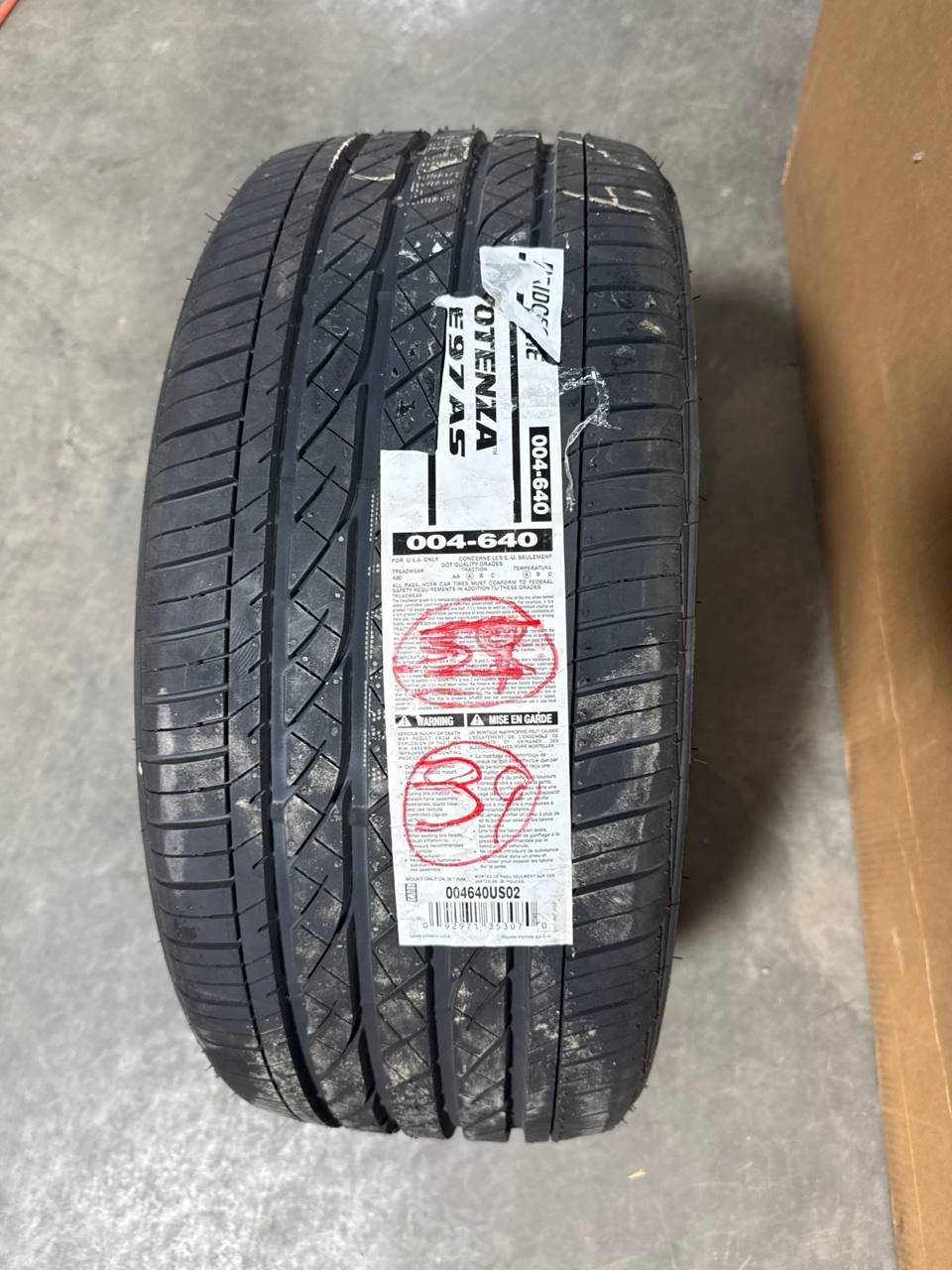 Close-up of the Bridgestone Potenza RE97AS tire tread with the manufacturer label still attached