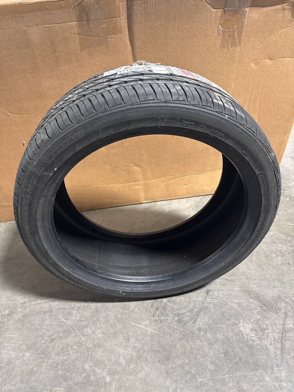 Bridgestone Potenza RE97AS tire, size P245/40R20, standing upright in the warehouse