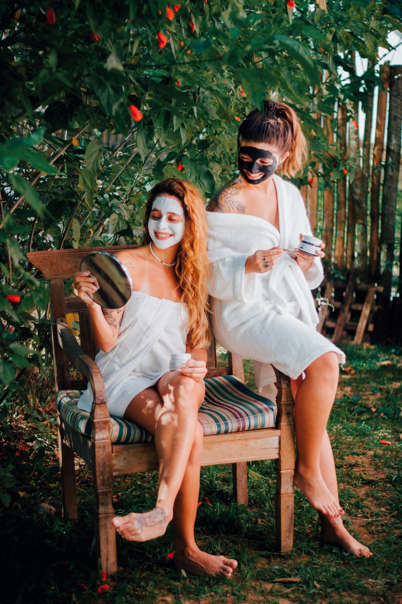 two girls taking a break from the sauna with face masks and robes