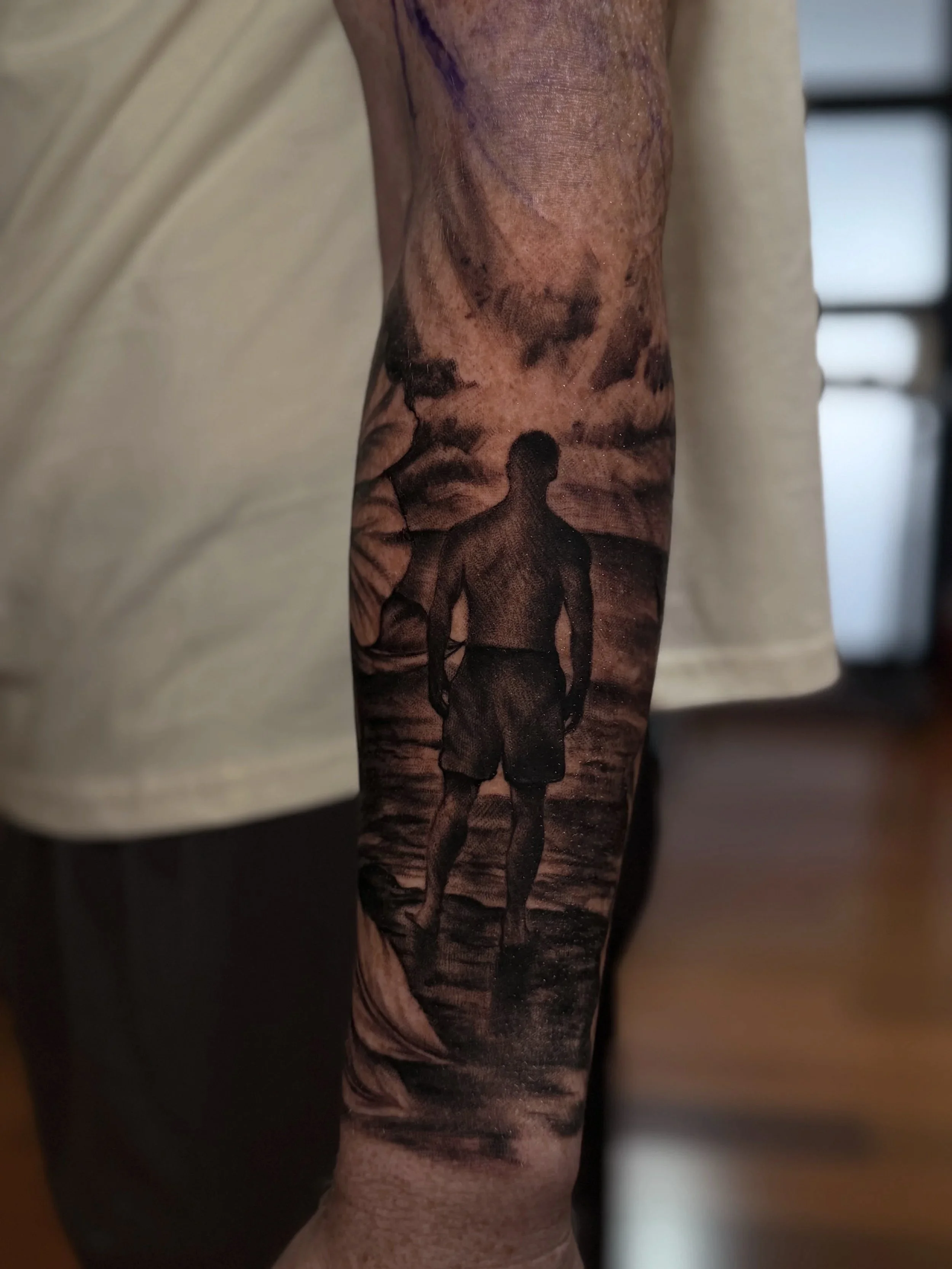Close-up of a detailed black-and-gray elephant tattoo covering a person's forearm.