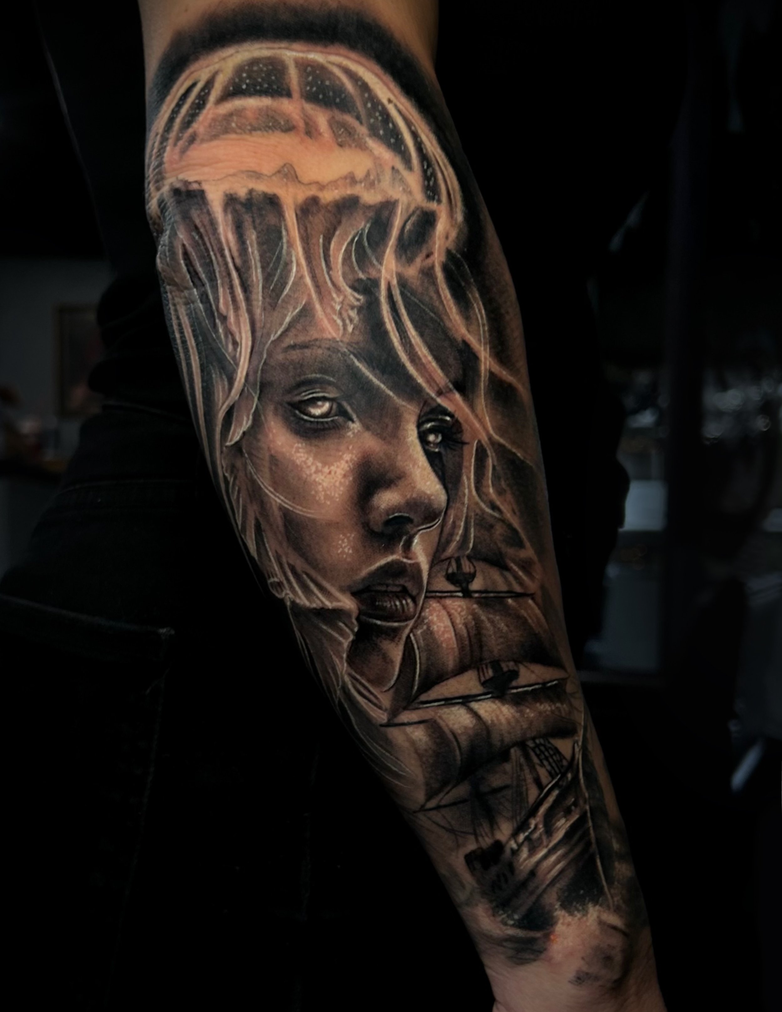 Close-up of a detailed tattoo depicting a lion’s face with a mane and crown-like design on a person’s upper arm