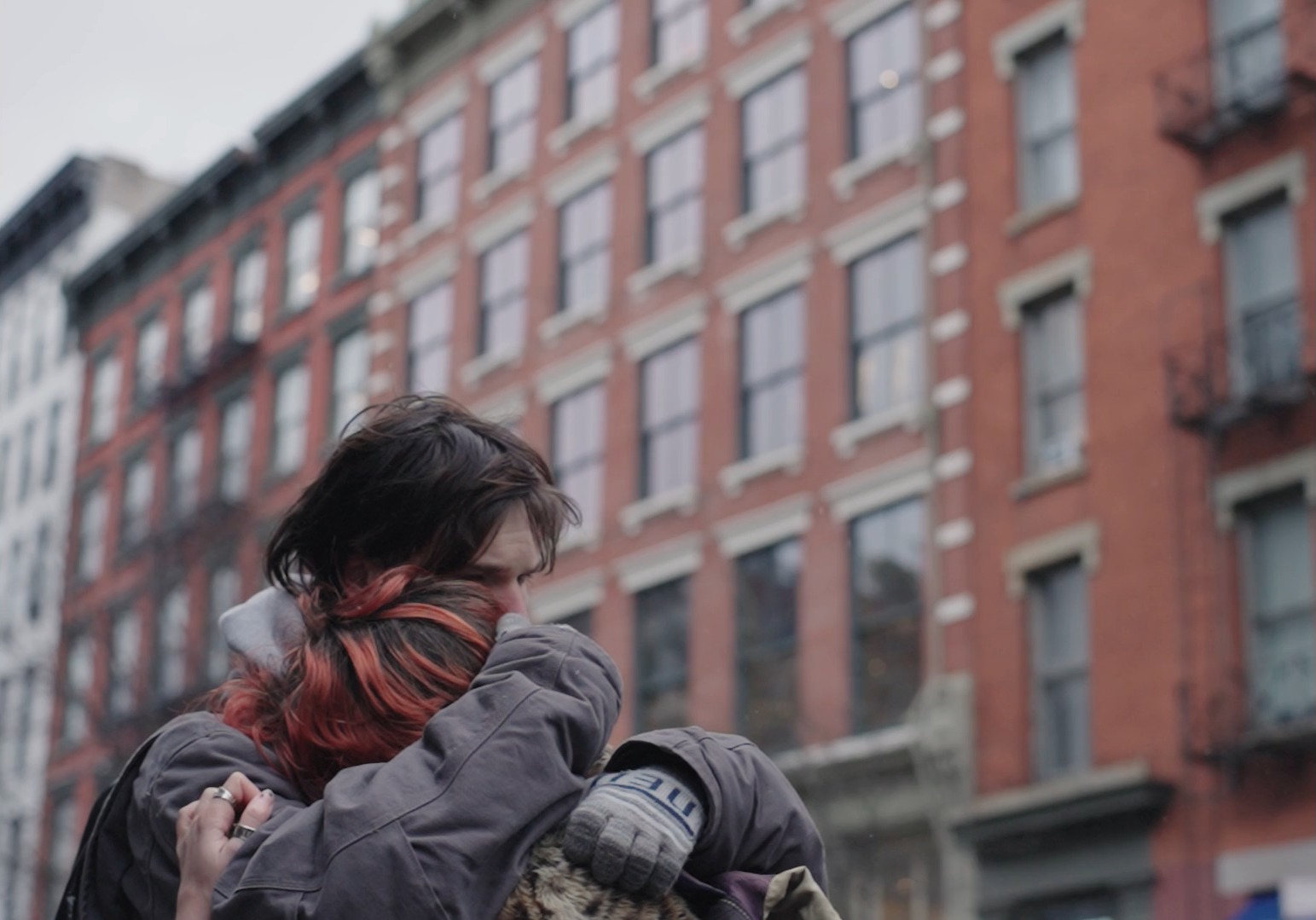 Two people embracing on a city street, still from Mushroom Cloud, a music video for A.S. Fanning