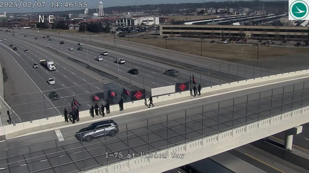 Neo-Nazi demonstrators wearing masks carrying large swastika-emblazoned flags stand along an Interstate 75 overpass near Lincoln Heights and Evendale, Ohio, on Feb. 7. Photo: Ohio Department of Transportation