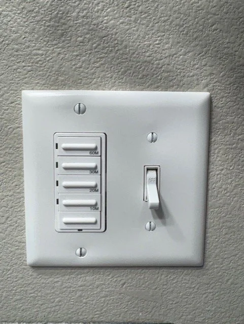 White wall plate with a dimmer switch and labeled 10-, 20-, 30-, and 60-minute timer controls