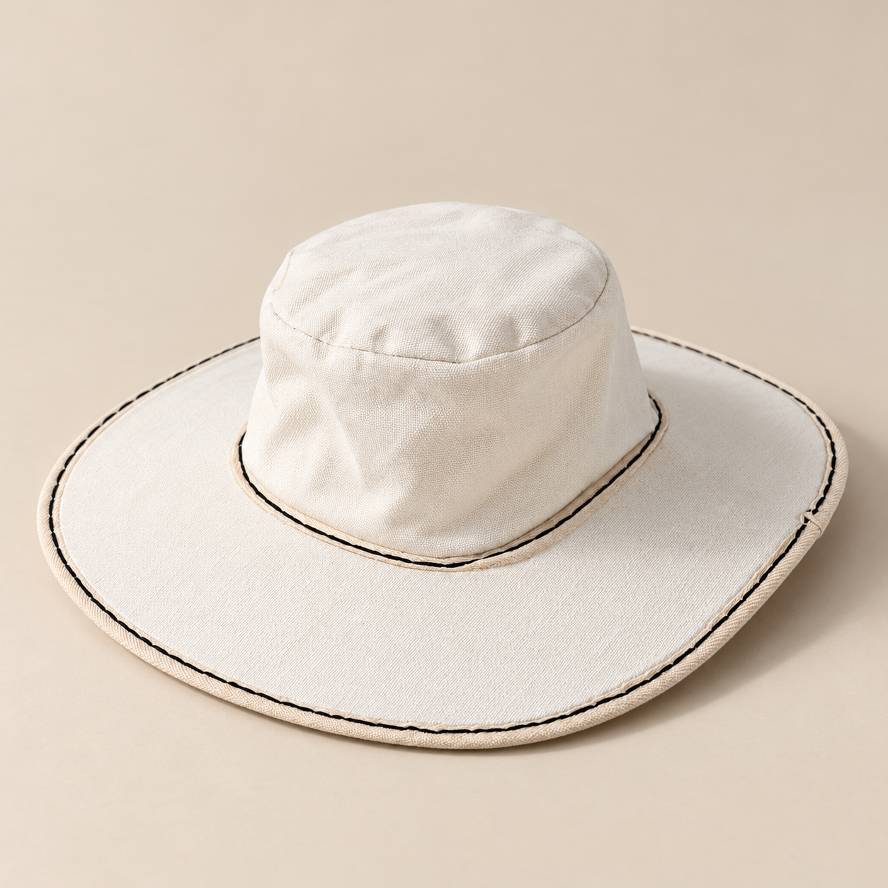 White canvas sun hat with a wide brim and black stitching