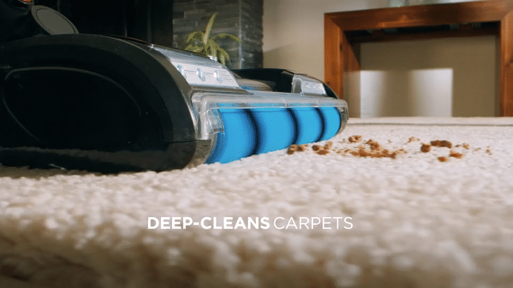 Carpet cleaner deep-cleaning a beige carpet with visible dirt and debris