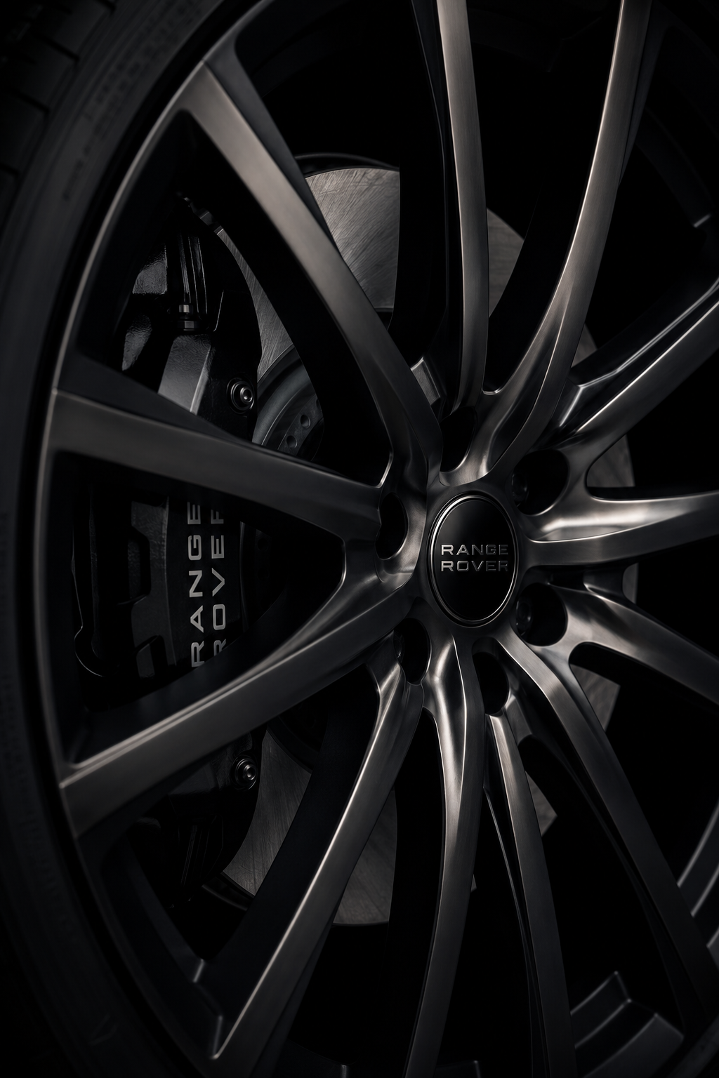 Close-up of a black Range Rover alloy wheel with multi-spoke design, brake rotor, and branded brake caliper.
