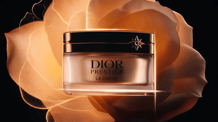 Dior Prestige La Crème luxury skincare jar displayed against an illuminated orange rose