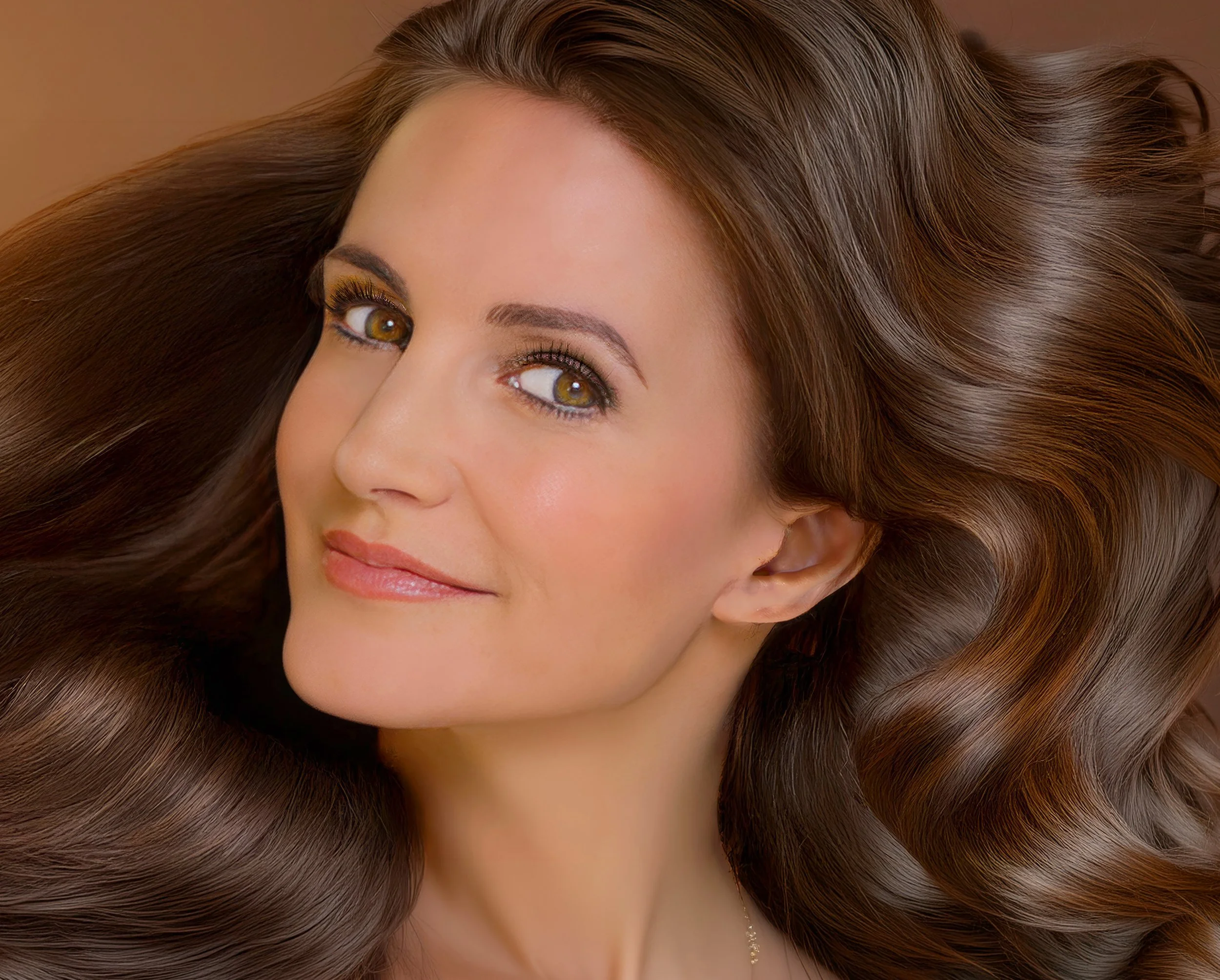 Close-up portrait of a woman with long brown hair, hazel eyes, and subtle makeup
