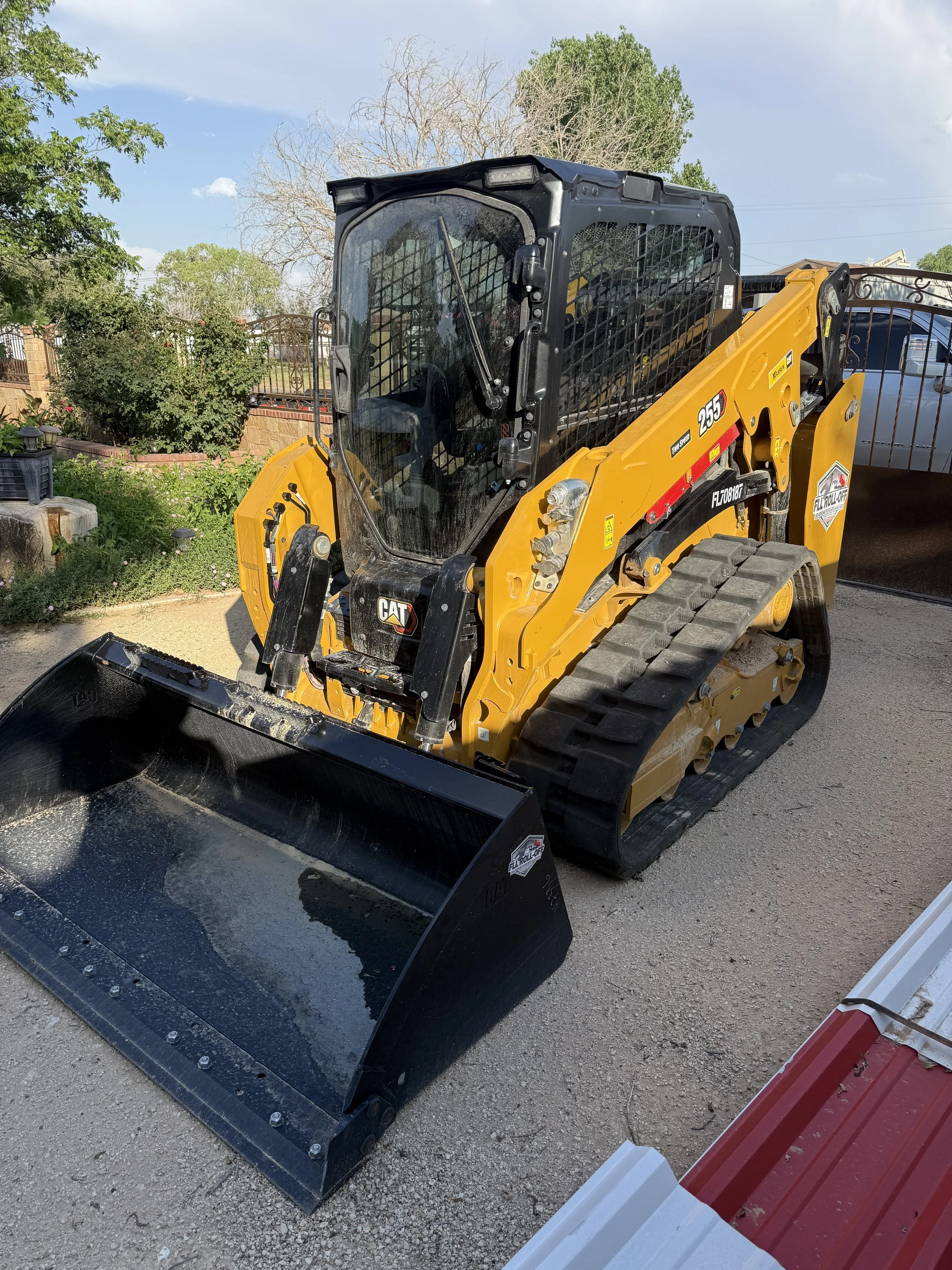 Yellow Caterpillar 259D3 tracked skid steer loader with a black bucket parked outdoors.