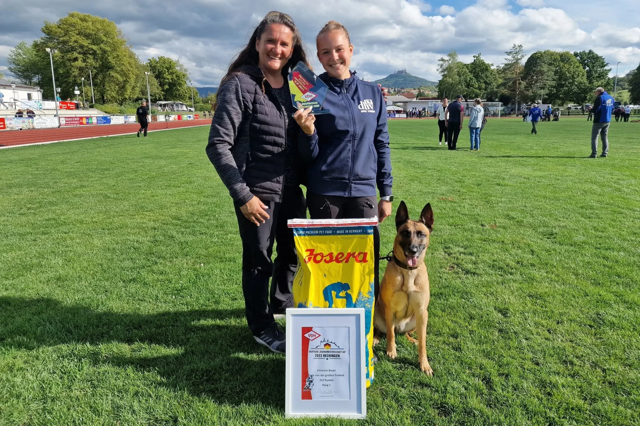 Hundetrainerinnen Joanna von JoBaDog und Vivienne von ViBaDog mit einem Malinois bei einem Hundesport-Wettkampf.