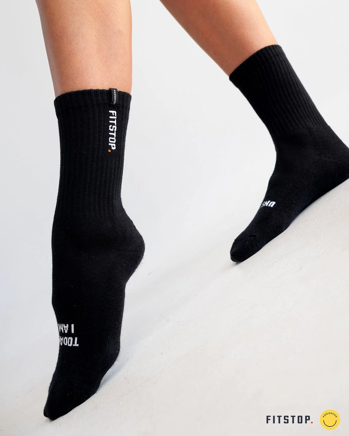 Pair of black ribbed FitStop crew socks worn on feet against a white background