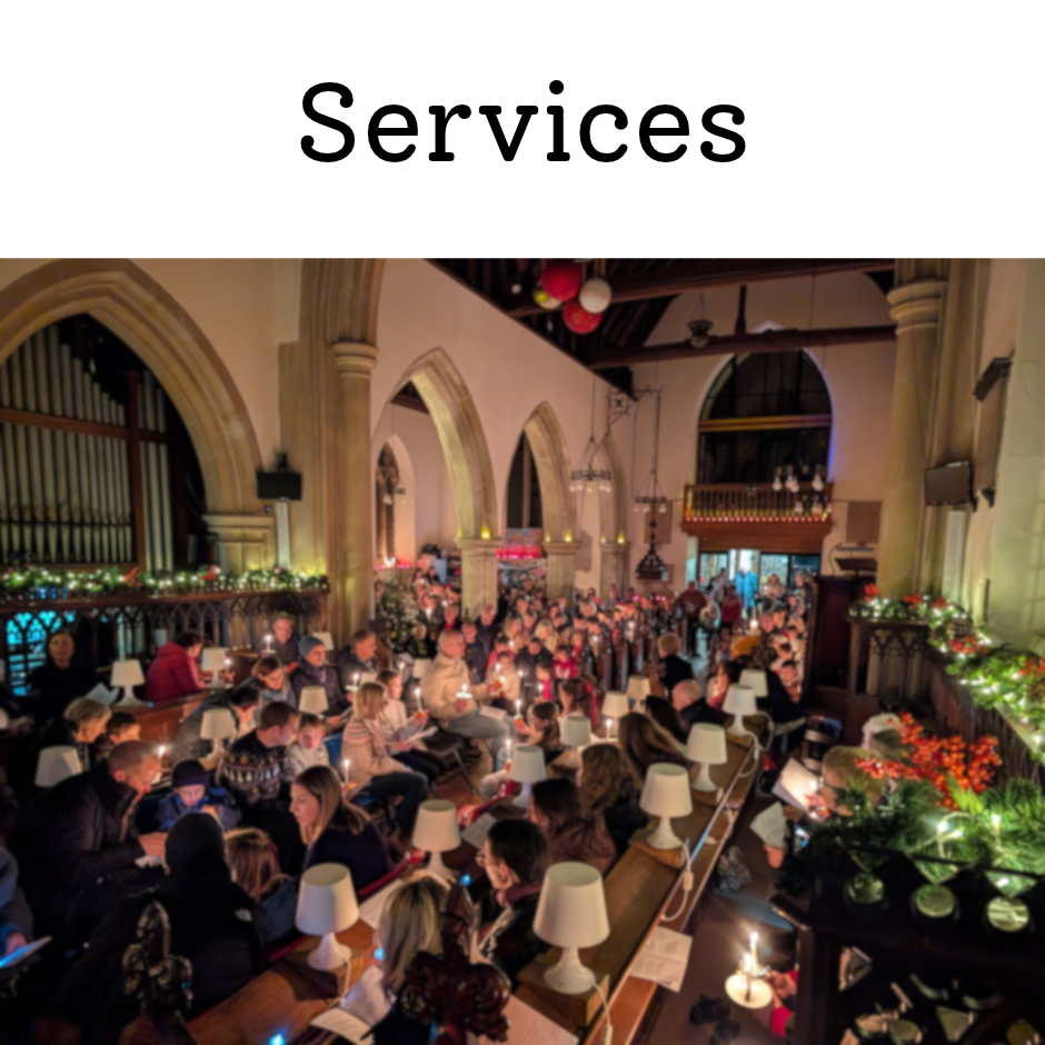 Crowded Christmas candlelight service inside a decorated historic church with organ pipes and arched architecture