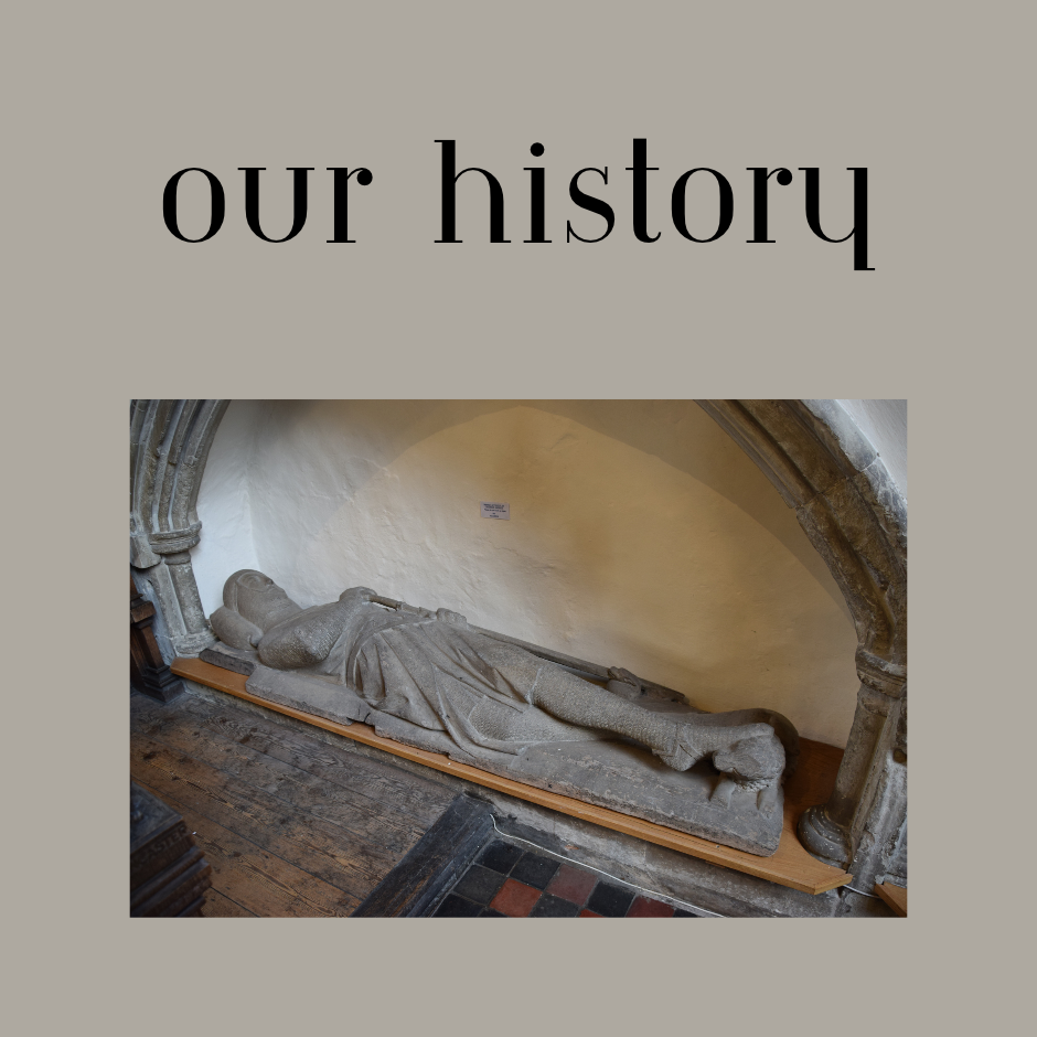 Stone medieval effigy of a reclining knight displayed beneath a Gothic arch in a historic church