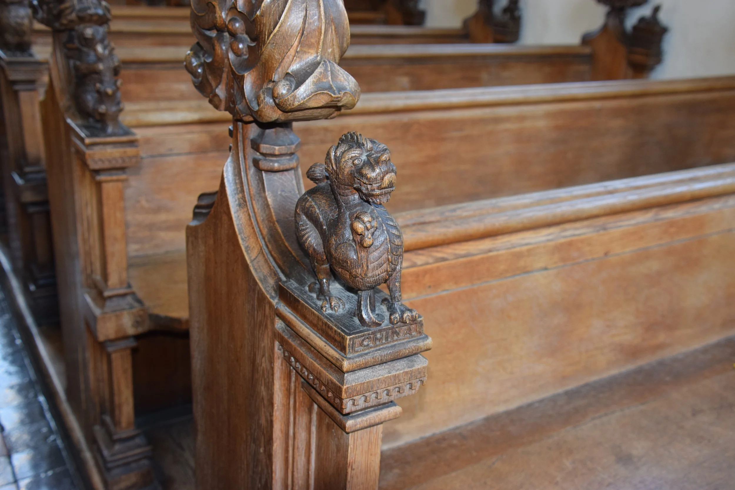 Intricately carved wooden lion ornament on an antique church pew