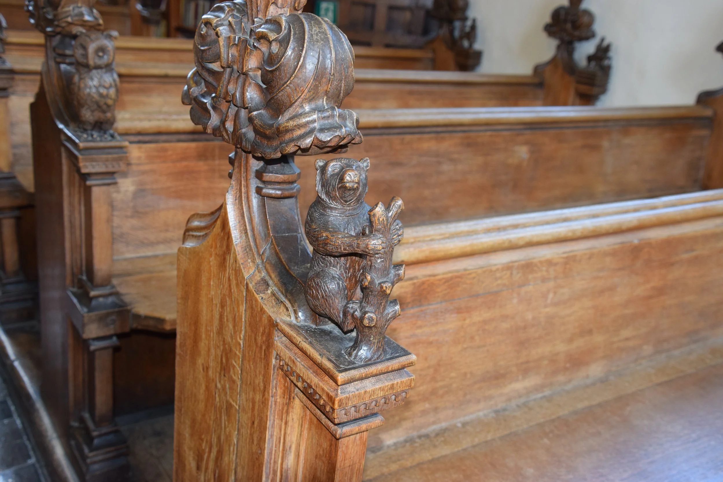 Close-up of an ornate carved wooden bear figure on a historic staircase newel post