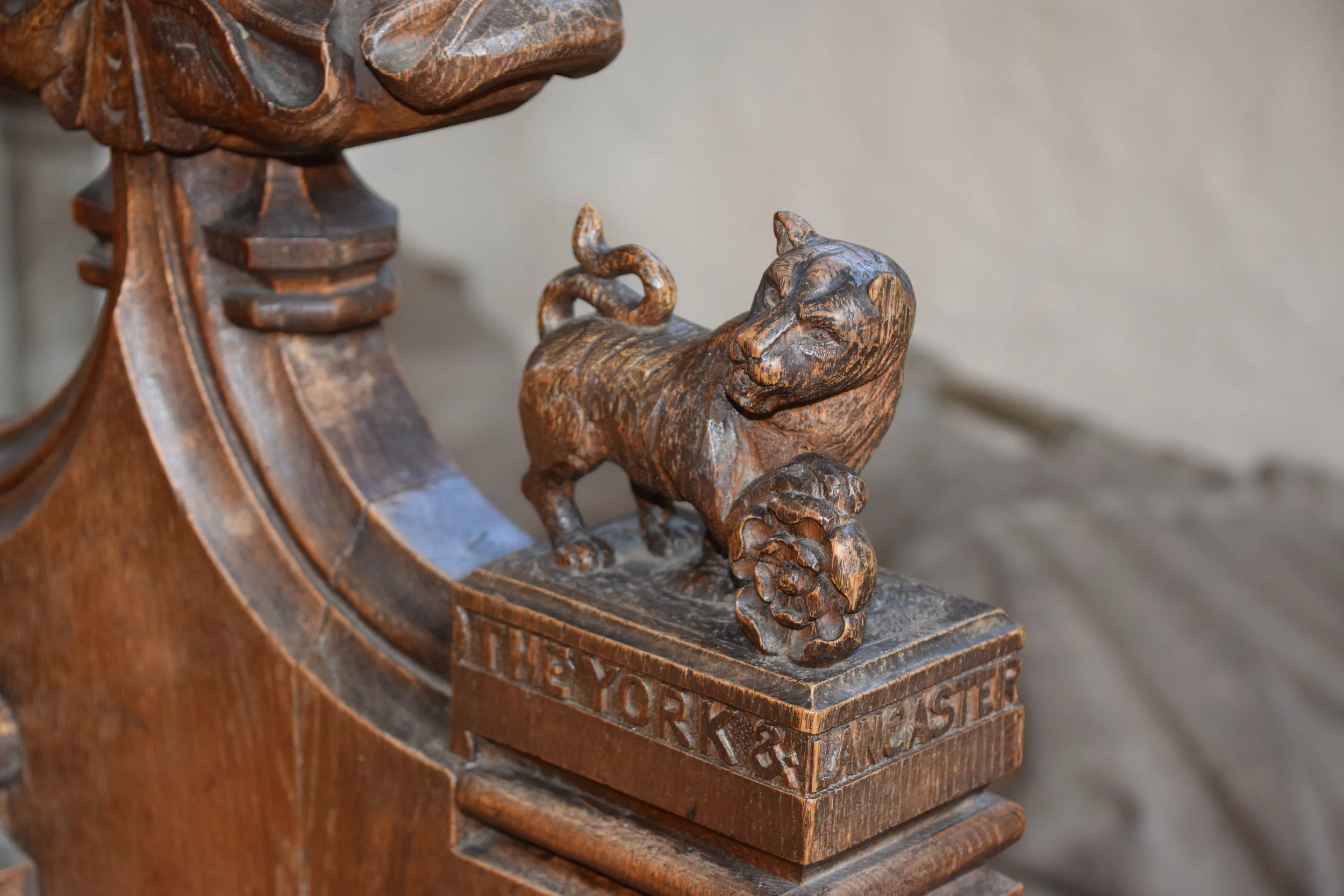 Close-up of an ornate carved wooden bear finial on a vintage wooden staircase post