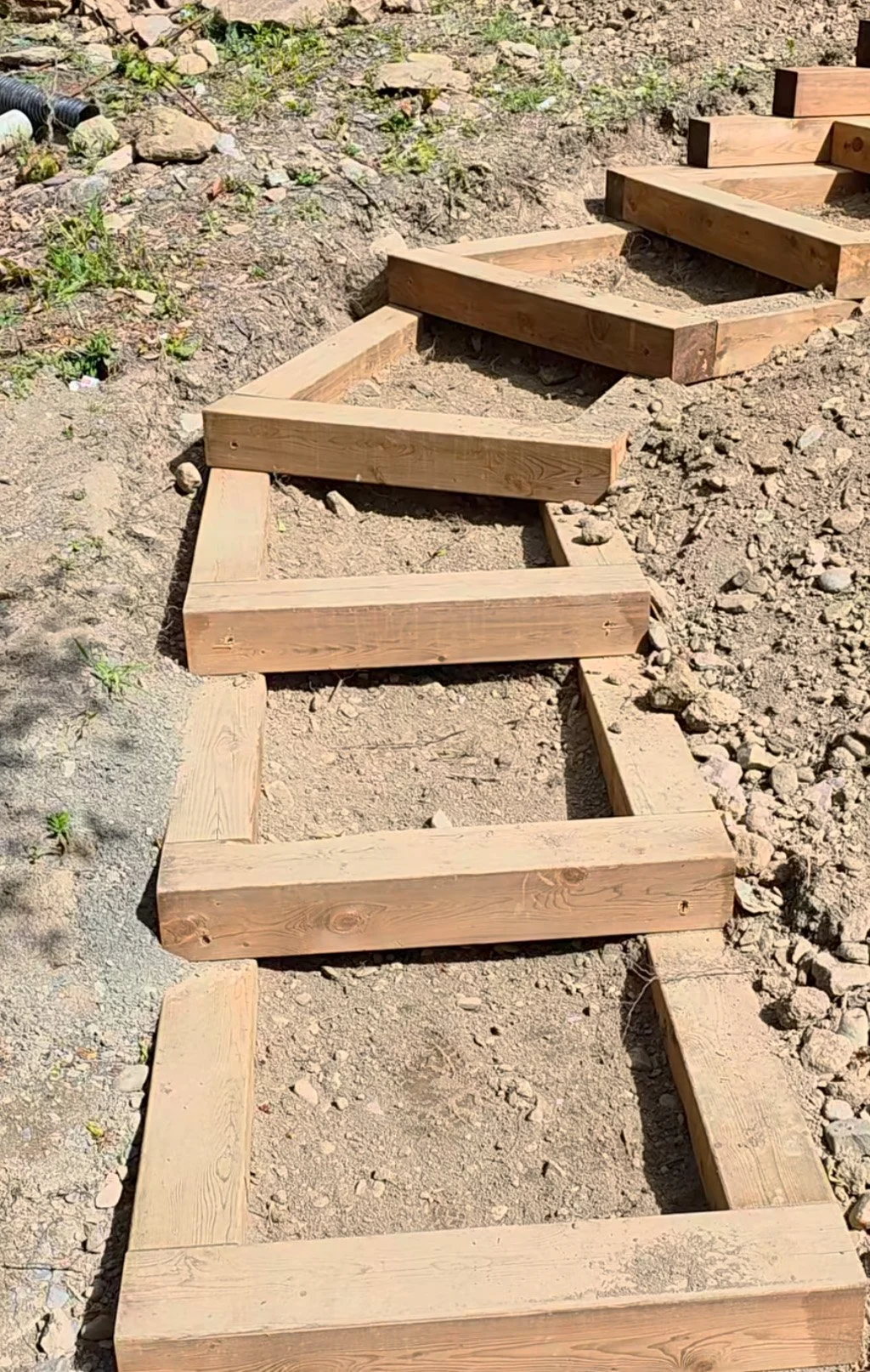 Wooden steps under construction on a rocky dirt hillside