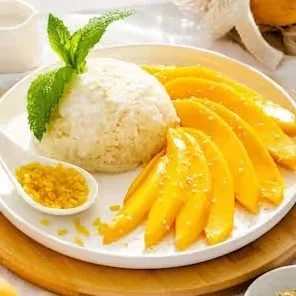 Thai mango sticky rice with sliced mango, coconut sticky rice, and mint garnish