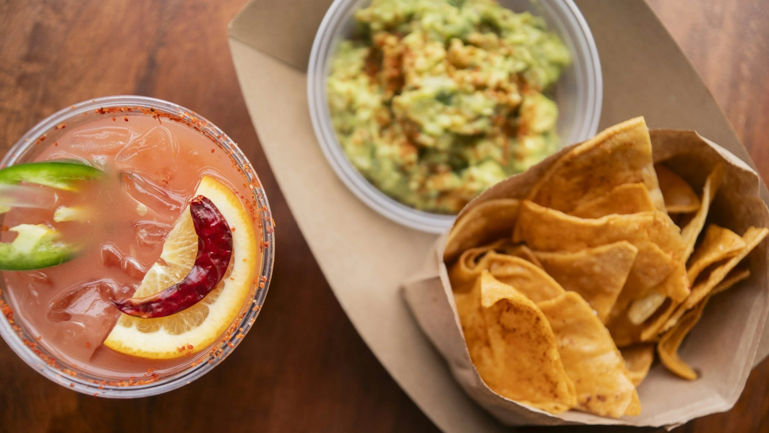 Guacamole, tortilla chips, and Paloma cocktail.